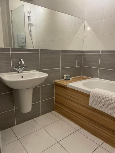 a bathroom with a sink and a bath tub at The Mey Hotel in Mey