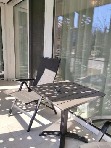 a table and chairs on a balcony with a table and a chair at Spa Residence Carbona EmDoNa Luxury Apartment in Hévíz