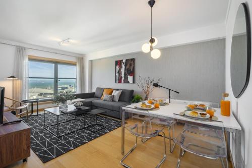 a living room with a couch and a table at WHome Panoramic View with Elevator, AC, Garage perfect for Families & Business Travellers in Lisbon