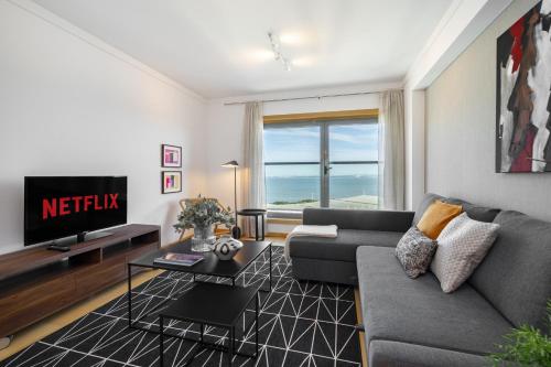 a living room with a couch and a tv at WHome Panoramic View with Elevator, AC, Garage perfect for Families & Business Travellers in Lisbon