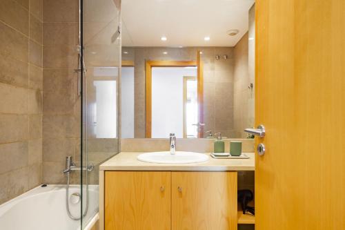 a bathroom with a sink and a shower and a tub at WHome Panoramic View with Elevator, AC, Garage perfect for Families & Business Travellers in Lisbon