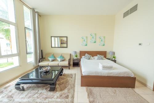 Budget Studio Apt near Metro Stn - IRN في دبي: غرفة معيشة مع سرير وطاولة قهوة