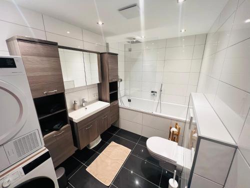 łazienka z wanną, umywalką i toaletą w obiekcie Modernes Apartment Seefeld and Chill RELAX im Zentrum mit Netflix for free w mieście Seefeld in Tirol