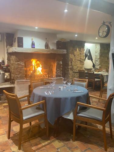a dining room with a table and a fireplace at Le Mas Saint Donat in Sainte-Maxime