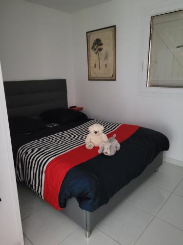 deux animaux farcis assis au-dessus d'un lit dans l'établissement Appartement Le Victoria Saint-Aygulf Fréjus, à Saint-Aygulf