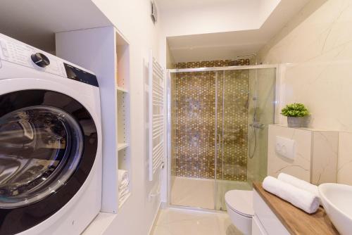 a washing machine in a bathroom with a shower at Apartmani Bokin in Bol