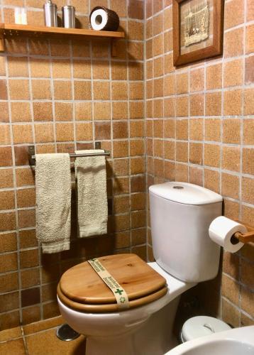 a bathroom with a toilet with a wooden seat at Casa do Ouriço in Figueiró dos Vinhos