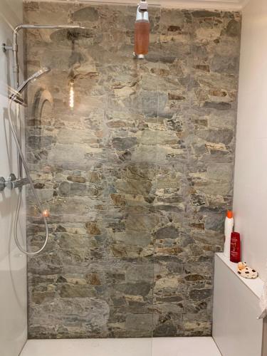 eine Dusche im Bad mit einer Steinmauer in der Unterkunft La Peñona, Carancos48, Nava in Nava