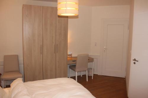 a bedroom with a bed and a table and chairs at lesboisjolis in Colmar