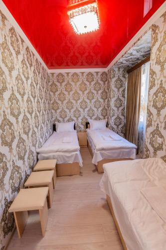 a room with three beds and a red ceiling at Rafting House in Odzun