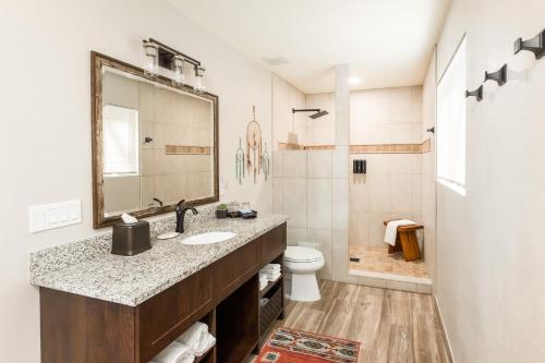 a bathroom with a sink and a toilet and a mirror at Whispering Creek Bed & Breakfast in Sedona