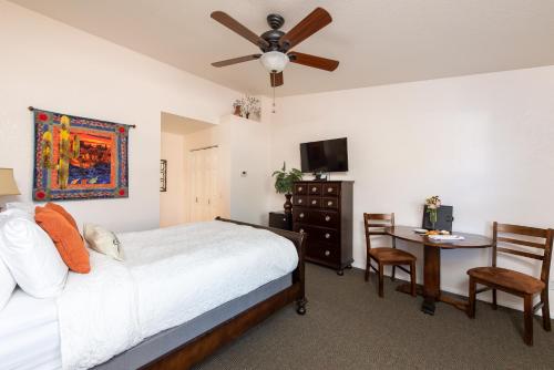 a bedroom with a bed and a desk and a ceiling fan at Whispering Creek Bed & Breakfast in Sedona