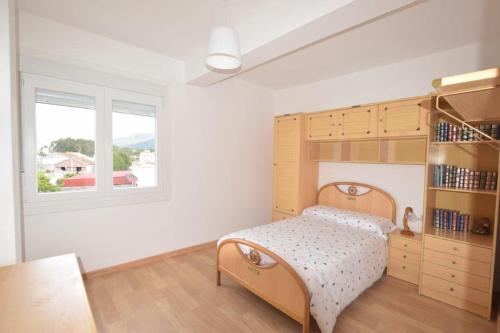 - une chambre avec un lit et une étagère dans l'établissement Apartamento en Carnota, à Carnota