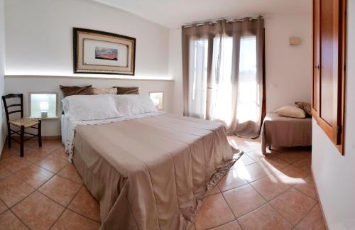 a bedroom with a bed and a chair and a window at Missipezza Residence a Frassanito in Alimini