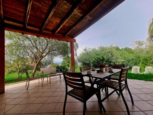 un patio con mesa y sillas en L'oasi nello Zingaro en Scopello