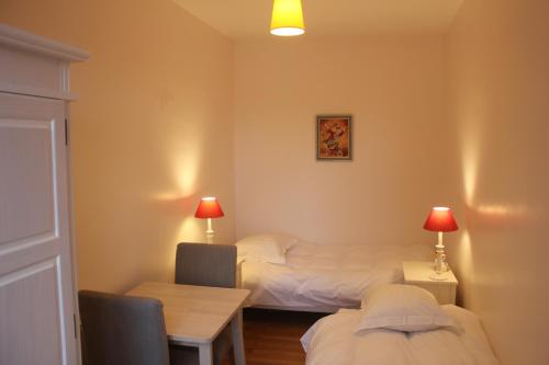 a room with two beds and a table and a desk at lesboisjolis in Colmar