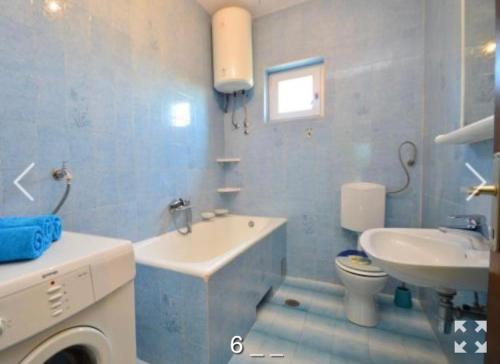 a blue bathroom with a sink and a toilet at Holiday Home Endi in Unešić
