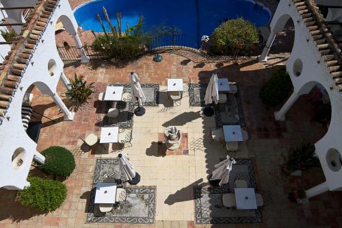 a patio area with tables, chairs and umbrellas at Hotel Residencia Miami in Torremolinos