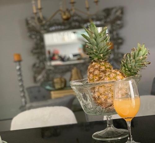 a bowl of pineapple and a glass of orange juice at Casa hermosa amoblada norte de Valledupar in Valledupar