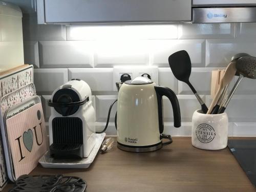 a kitchen counter with a coffee maker and a tea kettle at La casita de Olivia Espinaredo in La Villa