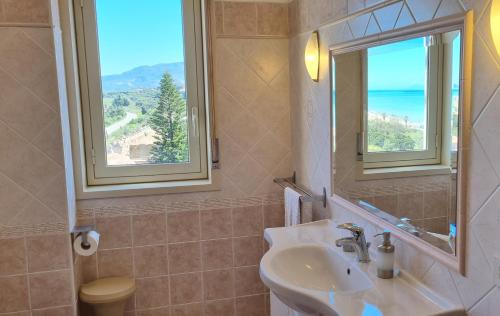 ein Badezimmer mit Waschbecken, Spiegel und Fenster in der Unterkunft Miramare Apartment in Acquedolci