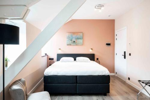 a bedroom with a king sized bed in a attic at L'ARTiste in Lessines