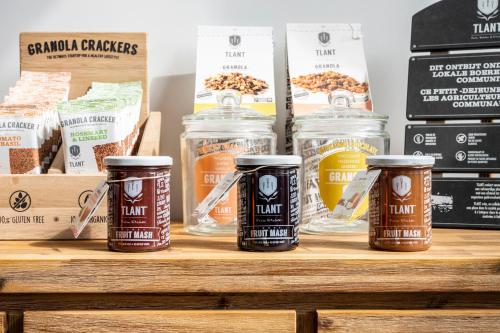 a shelf with jars of granola and other food items at L'ARTiste in Lessines