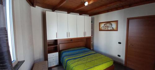 Dormitorio pequeño con cama y armarios blancos en Casa Mango en Stresa