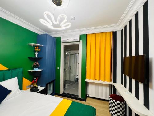 ein Schlafzimmer mit farbenfrohen Wänden, einem Bett und einem TV in der Unterkunft Apex Hotel in Istanbul