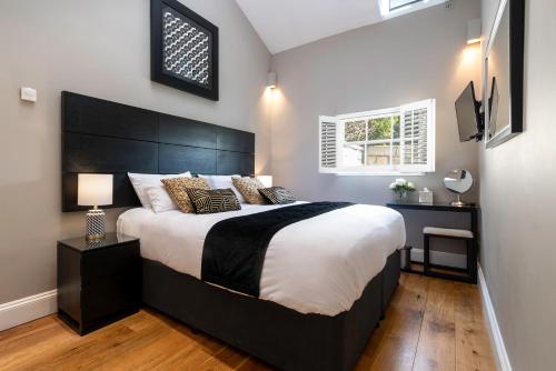 a bedroom with a large bed with a black headboard at Bath Circle Camden Lodge House in Bath
