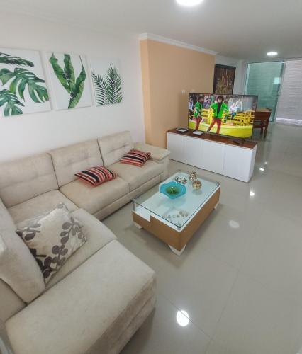 sala de estar con sofá y mesa de centro en Hermosa Casa Grande De 3 Pisos Barranquilla, en Barranquilla