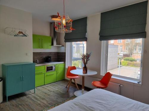 a kitchen with green cabinets and a table and chairs at Neon Nights Studio in Groningen