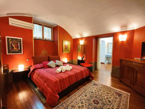 a bedroom with orange walls and a bed with a redspread at Hostdomus - Aqua Suite in Turin