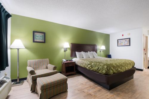 a hotel room with a bed and a chair at Econo Lodge Inn & Suites Knoxville East in Knoxville