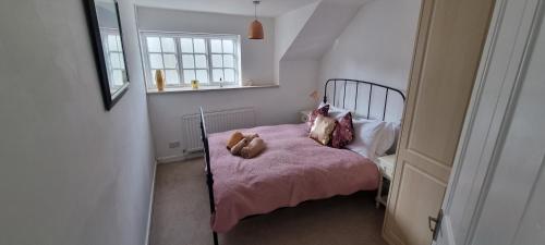 ein Schlafzimmer mit einem Bett mit einem Teddybär drauf in der Unterkunft York House in Conwy