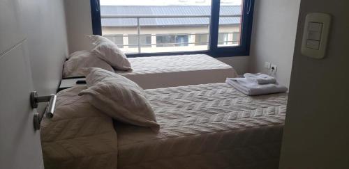 Duas camas num quarto com uma janela em Plaza Temporary Apartments em Rio Grande