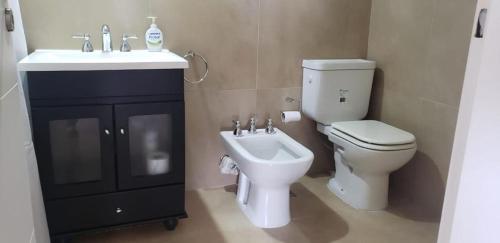 uma casa de banho com um WC e um lavatório em Plaza Temporary Apartments em Rio Grande