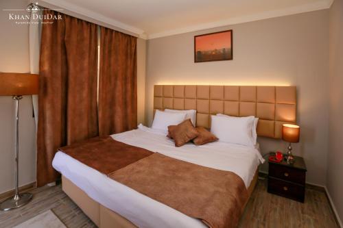 a bedroom with a large bed in a room at Khan Duidar Inn - Pyramids View Rooftop in Cairo