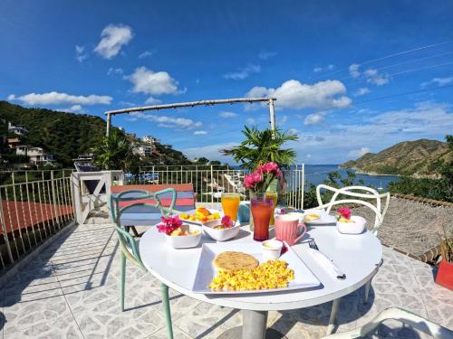 - une table avec de la nourriture et une vue sur l'océan dans l'établissement Tayrona Colors Hostel, à Taganga