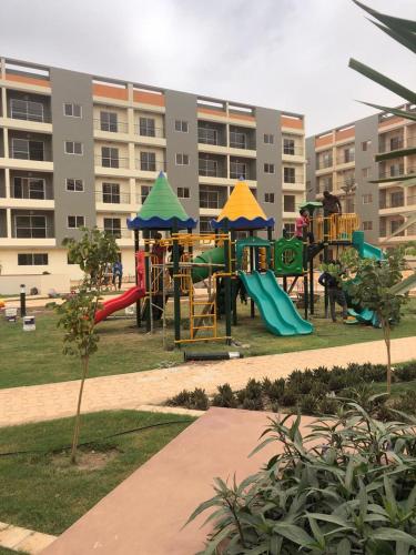 a playground with slides and play equipment in a park at Mo Residence SD City in Dakar