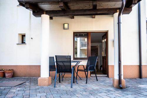 un patio con tavolo e sedie di fronte a un edificio di Apartments Krašna a Postumia