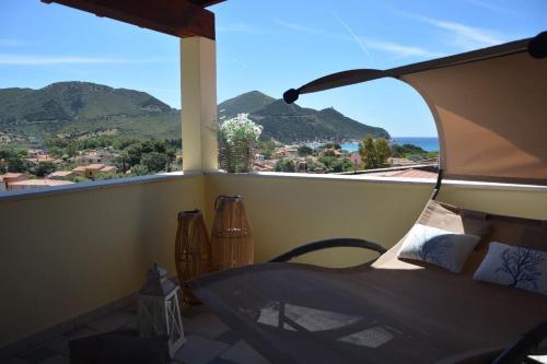 a room with a balcony with a view of mountains at Hotel Solanas in Solanas