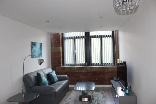 a living room with a couch and a table at Luxury Serviced Apartments in Bradford