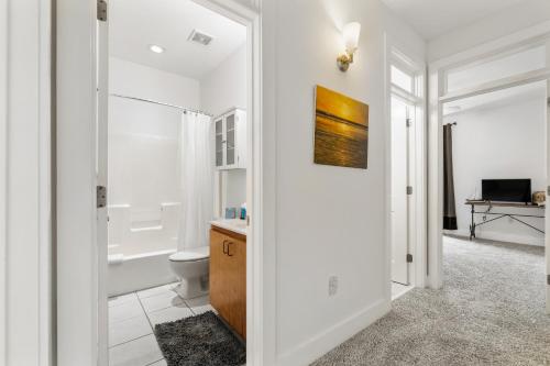 a white bathroom with a toilet and a sink at Old East Hill Townhouse in Pensacola
