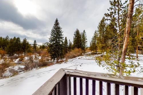 a wooden fence in the snow with trees at Hi Country Haus Hideaway in Winter Park