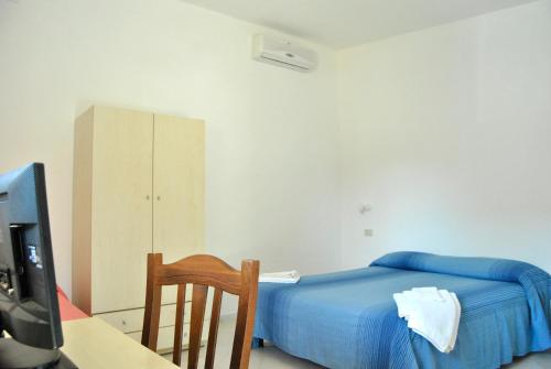 a bedroom with a bed and a desk and a tv at C'era Una Volta in Ricadi