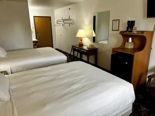 a hotel room with two beds and a mirror at Buffalo Bill's Antlers Inn in Cody