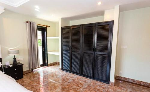 a bedroom with black shutter doors and a bed at Bayon Boutique Hotel សណ្ឋាគារប៊ូទិកបាយ័ន in Siem Reap