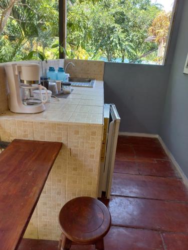 a kitchen with a counter and a table and a stool at Donde Familia Manito in Paquera