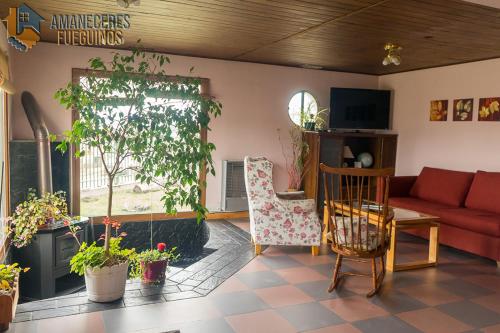 sala de estar con sofá rojo y algunas plantas en Tu casa en el Fin del Mundo en Ushuaia